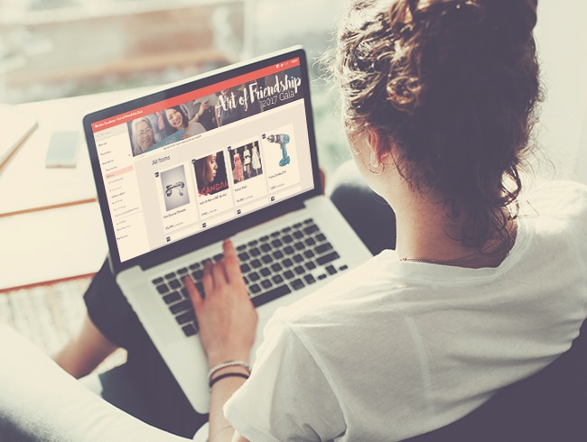 Volunteer setting up her event fundraising software on a laptop computer