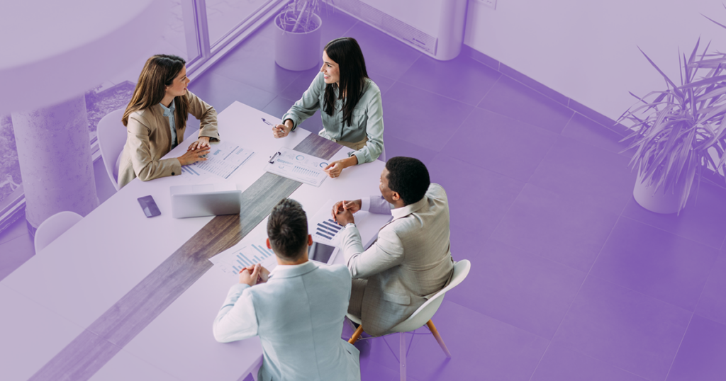 A team of four sitting at a table working.